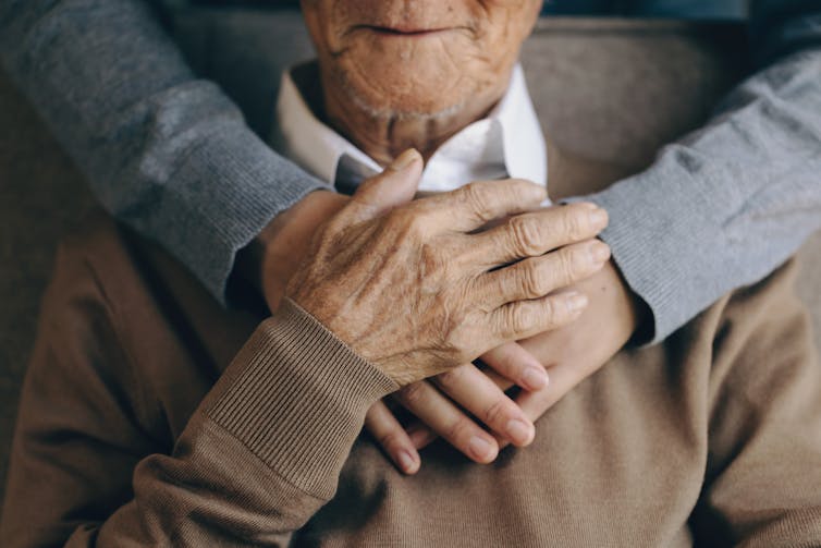 close up of a young person's hands wrapped around an older person